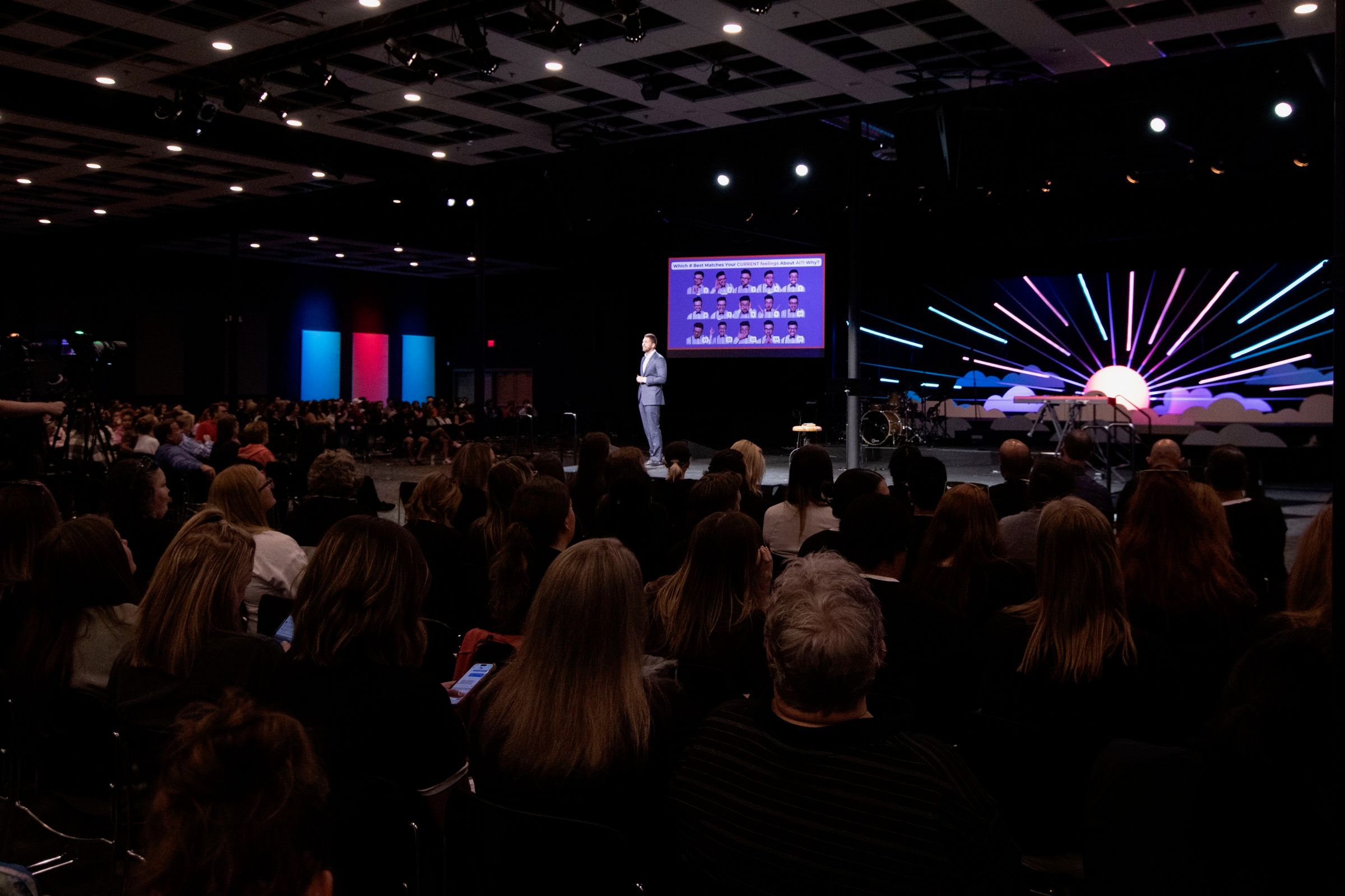 A full auditorium watching a keynote, seen from the back of the room.